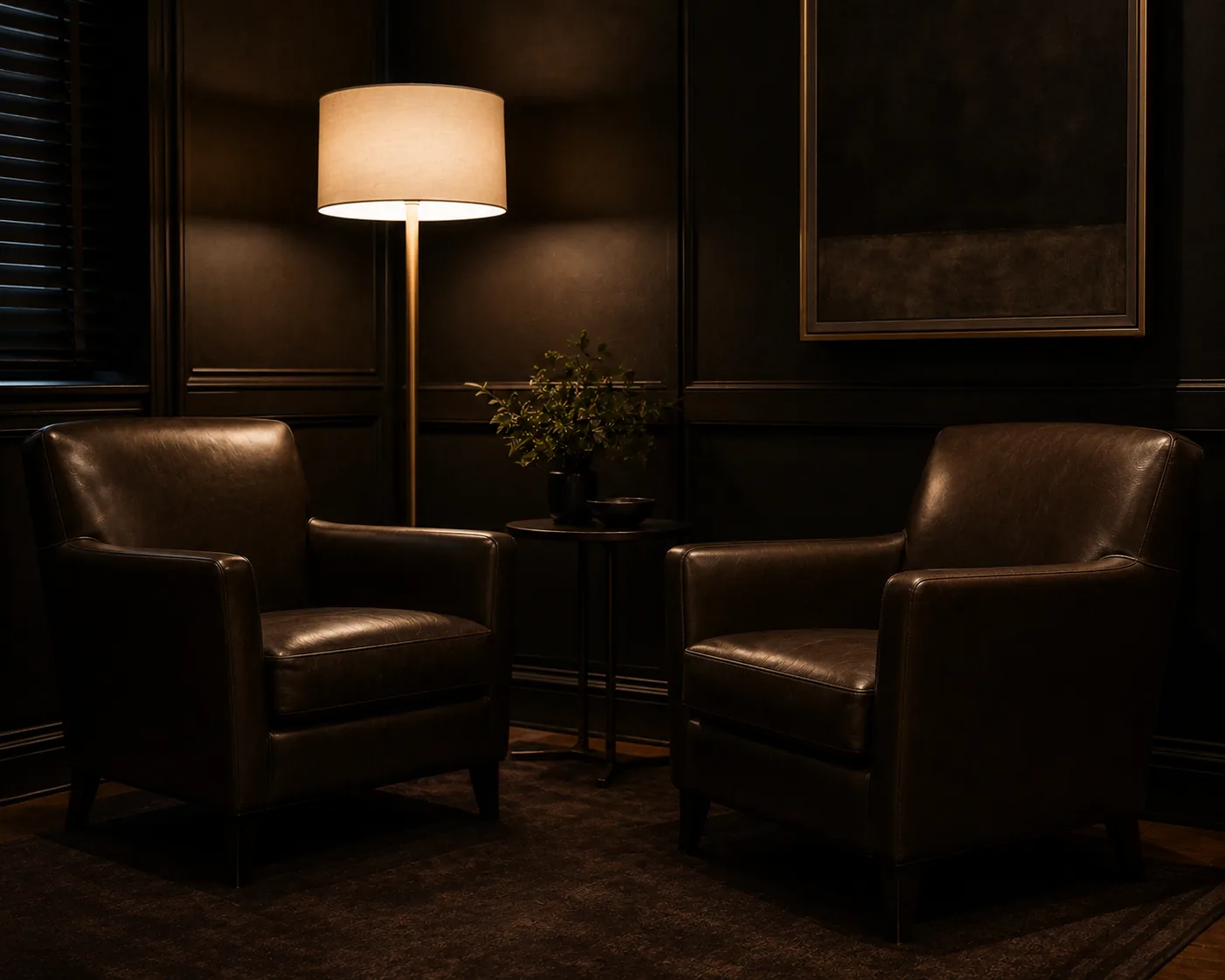 A quiet consultation room with two leather chairs and a warm floor lamp